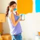 Chica joven probando materiales de pintura para disimular imperfecciones de una pared