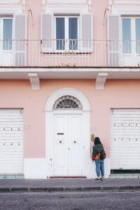 Mujer entrando a su casa con fachada recién pintada por Caubal Pintores, en Valencia