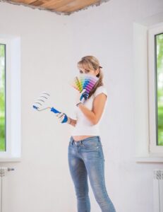 Mujer con paleta de colores y rodillo para elegir el color de la habitación