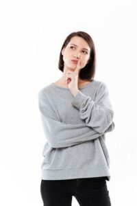 Mujer pensativa decidiendo si pintar toda la casa o solo una parte